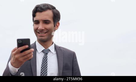 Junger städtischer Geschäftsmann, der mit dem Smartphone unterwegs ist Stockfoto