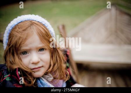 Ein rothaariges Mädchen, das sich für kaltes Wetter zusammengebündelt hat. Stockfoto