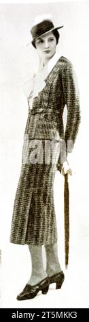 Ein australisches Magazin aus dem Jahr 1934 für „Anzüge für sonnige Tage“, in dem eine junge Frau in einem so gekleideten Outfit aus Yorkshire Tweed mit Querbalken kleidet ist. Die Bluse aus Seidenpikee und der Strohhut mit steifer Krempe sind die neuesten Accessoires.“ Stockfoto