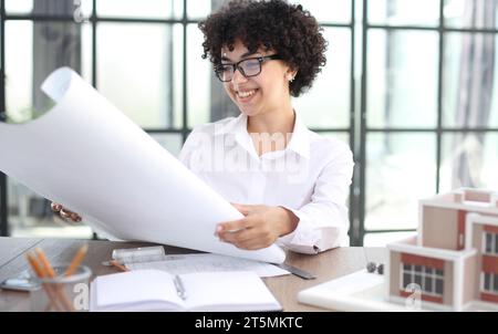 Die Architektin untersucht die Grundrisse des Hauses Stockfoto