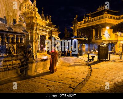 Eine nepalesische Frau zündet Kerzen im Swayambhunath Tempel in Katmandu an. Stockfoto