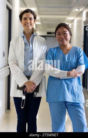 Porträt lächelnder Ärztinnen mit Tablette im Krankenhauskorridor Stockfoto