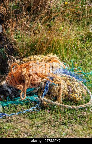 Zurückgeworfene Fischernetze an einem Strand, die nach dem Ausbrechen von kommerziellen Fischerbooten aufgespült wurden, was eine Bedrohung für die Tierwelt und die Umwelt und eine Umfrage zur Folge hatte. Stockfoto