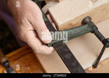 Man Zimmermann klemmt Brett in Schraubstock Stockfoto