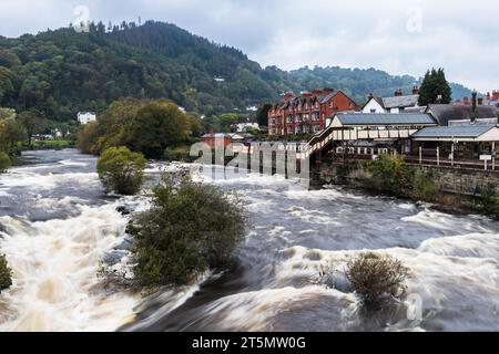 Weißes Wasser auf dem Fluss Dee, als es durch die walisische Stadt Llangollen stürzt, aufgenommen am 23. Oktober 2023. Stockfoto