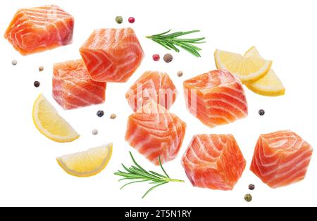 Frische Lachsstücke, Gewürze und Zitronenscheiben, die in der Luft schweben, auf weißem Hintergrund. Datei enthält Beschneidungspfade. Stockfoto