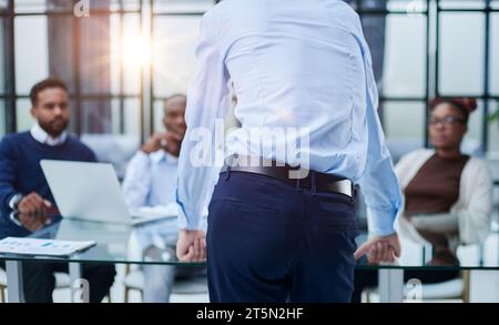 Junger Mitarbeiter, der um Rat von seinen hilfsbereiten, erfahrenen Kollegen im Büro bittet Stockfoto