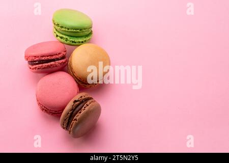 Bunte französische Makronen isoliert auf pinkfarbenem Hintergrund. Draufsicht. Stockfoto