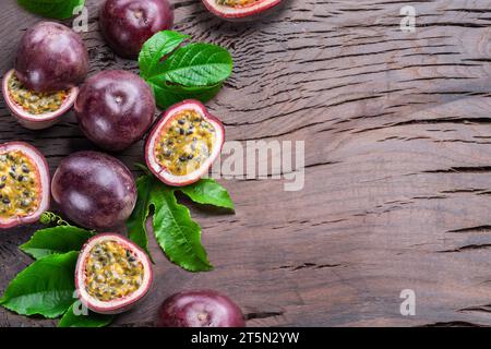 Dunkellila Passionsfrüchte und die Hälfte mit scheinbar Innenausstattung auf einem Holztisch. Stockfoto
