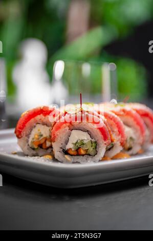 Sushi-Brötchen mit Thunfisch, Frischkäse, Gurke und Currysauce auf einem Teller. Hochwertige Fotos Stockfoto