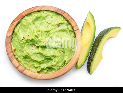 Guacamolensauce und Scheiben von Avocadofrüchten, isoliert auf weißem Hintergrund. Stockfoto