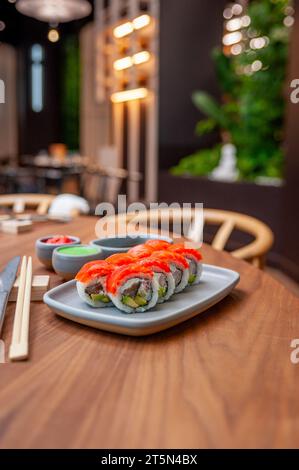 Sushi-Brötchen mit Lachs, Garnelen, Avocado und Frischkäse auf einem Teller. Hochwertige Fotos Stockfoto