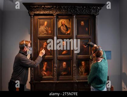 Die Konservatoren David Everingham und Alison Aynesworth arbeiten an der Restaurierung von 12 ölbemalten Tafeln auf dem Schrank des Apostels, die im Bronte Parsonage Museum in Haworth ausgestellt sind. Die Ölmalerkonservatoren arbeiten 12 Wochen damit, die Gemälde auf dem Schrank zu restaurieren, der von Charlotte Bronte in Jane Eyre beschrieben wird. Bilddatum: Montag, 6. November 2023. Stockfoto