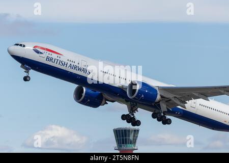 British Airways Boeing 777-300ER, Registrierung G-STBM verlässt London Heathrow lhr an einem schönen Sommerabend mit sichtbarem ATC-Turm Stockfoto