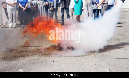 Schulung der Bevölkerung und der Arbeiter zum Löschen von Bränden. Gutes Beispiel. Feuer mit einem Feuerlöscher löschen. Stockfoto