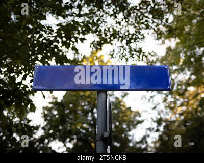 Leere blaue Vorlage für Straßennamensschilder. Metallplatte aus einem niedrigen Winkel. Der Kopierraum kann als Modell für Straßenschilder in Deutschland genutzt werden. Stockfoto