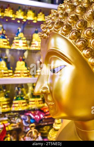 Ein Profil der Nase einer großen, goldenen Buddha-Statue zum Verkauf. An einer religiösen Ikone, einem Reliquienladen entlang der Bamrung Mueang Road in Bangkok, Thailand. Stockfoto