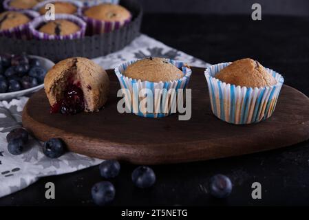 Köstliche hausgemachte Cupcakes gefüllt mit Heidelbeeren und präsentiert in kleinen Formen. Stockfoto