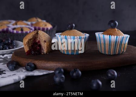 Köstliche hausgemachte Cupcakes gefüllt mit Heidelbeeren und präsentiert in kleinen Formen. Stockfoto
