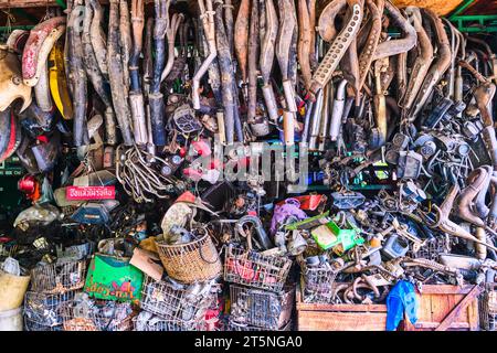 Eine riesige Sammlung von gebrauchten Schalldämpfern und verschiedenen Autoteilen in einer Werkstatt. Auf dem lokalen Rotfai Thonburi Markt in Bangkok, Thailand. Stockfoto
