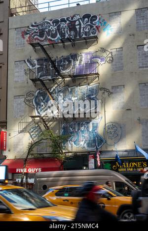 Farbenfrohe Graffiti markieren die Vorderseite des Gebäudes in Midtown Manhattan, 2023, New York City, USA Stockfoto