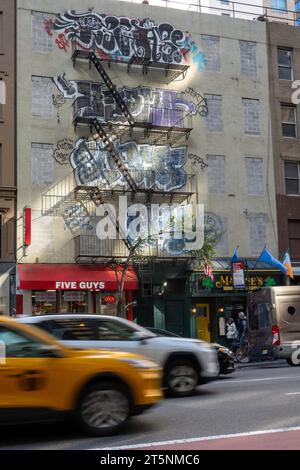 Farbenfrohe Graffiti markieren die Vorderseite des Gebäudes in Midtown Manhattan, 2023, New York City, USA Stockfoto