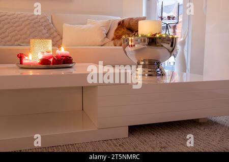 Dekoratives Ambiente mit Kerze im Sektkühler auf dem Tisch. Stockfoto