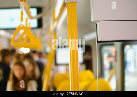 Innenraum eines Busses mit gelben Sitzen und Fahrgästen im Hintergrund Stockfoto