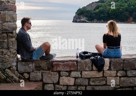 Touristen, die sich entspannen und die Aussicht von den Mauern der Altstadt von Budva, Montenegro, genießen Stockfoto