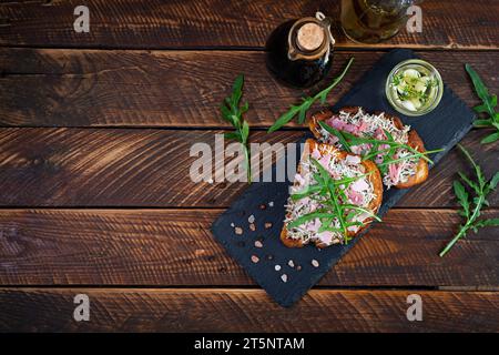 Gebratene Sandwiches mit karamelisierten Zwiebeln, gemischt mit Frischkäse und Kräutern. Gegrilltes Sandwich Stockfoto