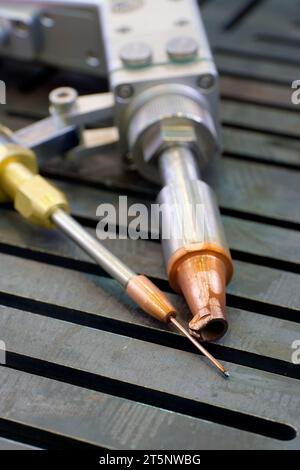 Laserstrahl-Schweißgerät, Handkollimatorbrenner, auf einem Arbeitstisch aus Stahl, Nahaufnahme. Stockfoto