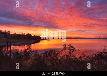 Leuchtend farbenfroher Sonnenaufgangshimmel und Reflexionen vom Ufer des Columbia River mit Blick auf Mt Hood, Oregon Stockfoto