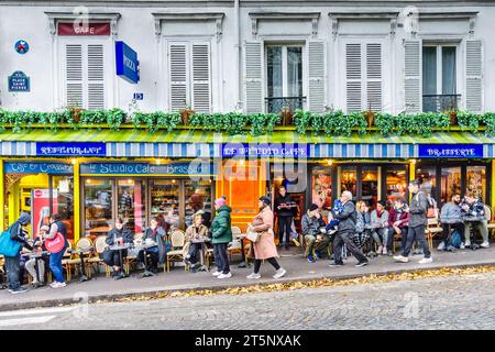 Touristen im beliebten "Le Studio Cafe" mit Blick auf Sacre-Coeur am Place Saint-Pierre, Montmartre, Paris 18, Frankreich. Stockfoto