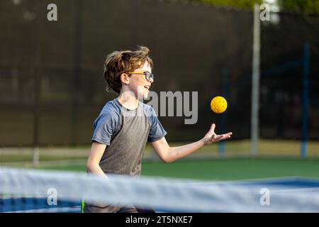 Junge auf dem Platz, der Pickleball spielt Stockfoto