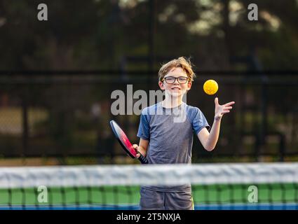 Junge spielt Pickleball auf dem Platz Stockfoto