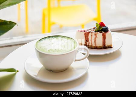 Latte Art mit japanischem grünem Tee Matcha Käsekuchen, weißer Tisch Stockfoto