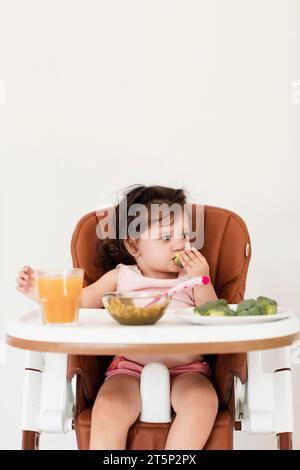 Baby Mädchen essen Kinderstuhl Stockfoto
