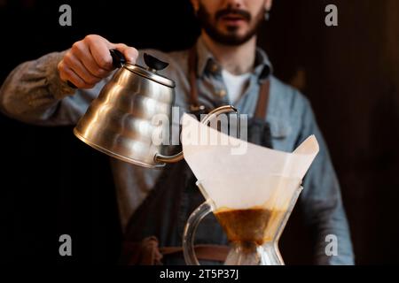 Nahaufnahme Mann, der Kaffee aus dem Topffilter gießt Stockfoto