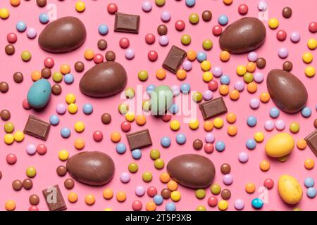 Erhöhte Aussicht Edelsteinbonbons Schokolade ostereier rosa Hintergrund Stockfoto