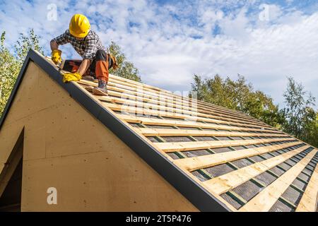 Professioneller Kaukasischer Bauarbeiter, Der Einen Harten Hut Trägt, Der Holzelemente Des Dachs Montiert Stockfoto