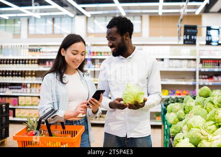 Glückliches multiethnisches Paar, das sich für einen Warenmarkt entschieden hat Stockfoto