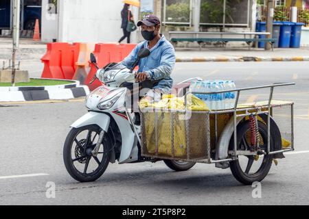 SAMUT PRAKAN, THAILAND, 11. Oktober 2023, Ein Mann fährt Motorrad mit einem beladenen Beiwagen Stockfoto