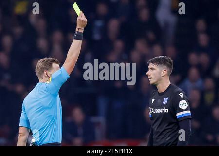 AMSTERDAM, NIEDERLANDE - 5. NOVEMBER: Schiedsrichter Sander van der Eijk und Pelle van Amersfoort (SC Heerenveen) zeigen die gelbe Karte während der Eredivisie Stockfoto