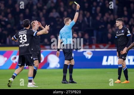 AMSTERDAM, NIEDERLANDE - 5. NOVEMBER: Schiedsrichter Sander van der Eijk und Pelle van Amersfoort (SC Heerenveen) zeigen die gelbe Karte während der Eredivisie Stockfoto