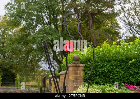 Ripley erinnert sich mit einem roten Mohn und Soldaten im malerischen Dorf in der Nähe von Harrogate. Stockfoto