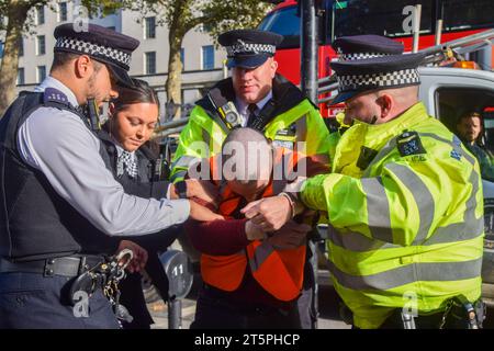 London, Großbritannien. November 2023. Polizisten verhaften während der Demonstration einen Demonstranten. Die Polizei verhaftete Dutzende von Just Stop Oil Aktivisten in Whitehall, während die Klimagruppe ihre langsamen Märsche aus Protest gegen neue Genehmigungen für fossile Brennstoffe fortsetzt. (Foto: Vuk Valcic/SOPA Images/SIPA USA) Credit: SIPA USA/Alamy Live News Stockfoto