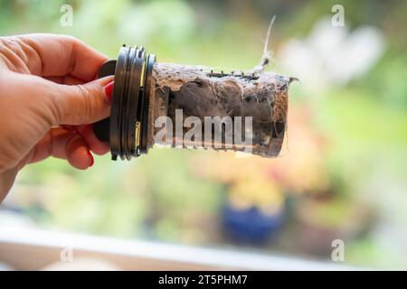 Ein verstopfter verschmutzter Filter aus der Waschmaschine wird entfernt und gereinigt, um die Verstopfung zu beheben. Stockfoto