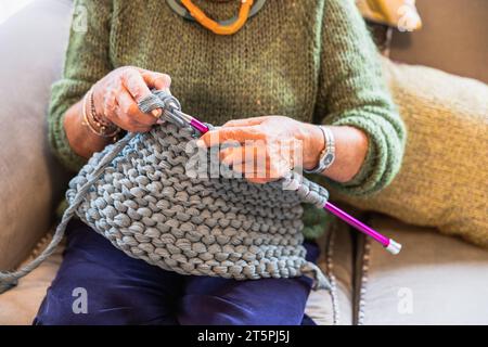 Nahaufnahme der Wolle und Nadeln der Strickarbeit der Frau Stockfoto