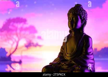 Buddha Purnima und Vesak Tageskonzept, Buddha-Statue mit dezentem Licht vor wunderschönem und farbenfrohen Hintergrund aus nächster Nähe. Meditation Stockfoto