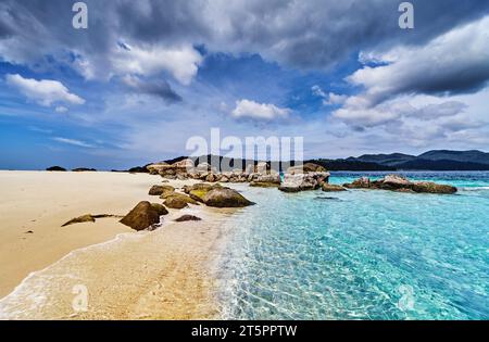 Wunderschöner tropischer Strand mit klarem türkisfarbenem Wasser und blauem Himmel mit Wolken in Thailand Stockfoto